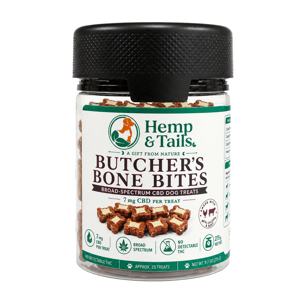 A jar of Hemp & Tails Butcher's Bone Bites dog treats, featuring a black textured lid and a white label with green and brown accents, set against a plain white background.