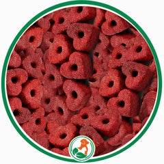 Ruby-red heart-shaped Ruby Cake Hearts dog treats with center holes in a green circular border.