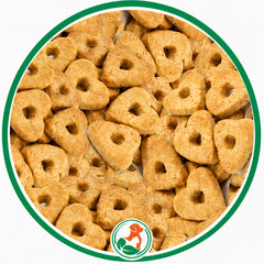 Golden Peanoat Hearts dog treats with small center holes in a green-bordered circular close-up.